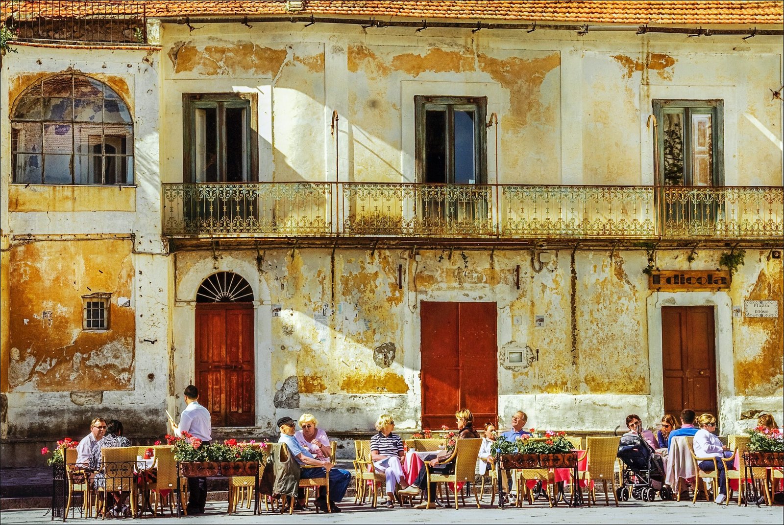 people sitting on chairs near brown concrete building during daytime