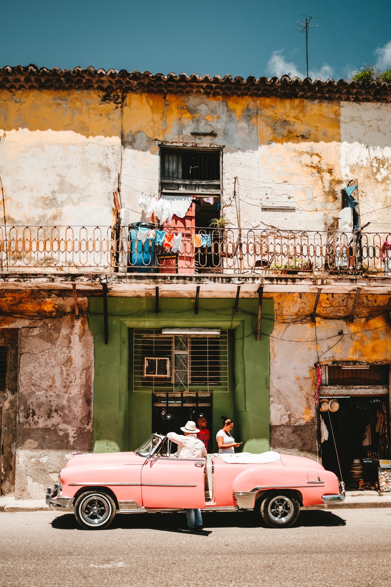 person standing beside of pink convertible car